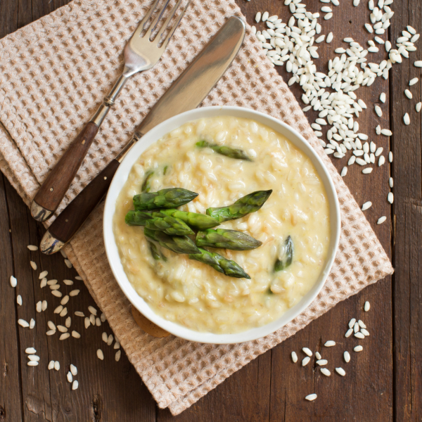 assiette de risotto avec des asperges verte et du riz parsemé de parmesan